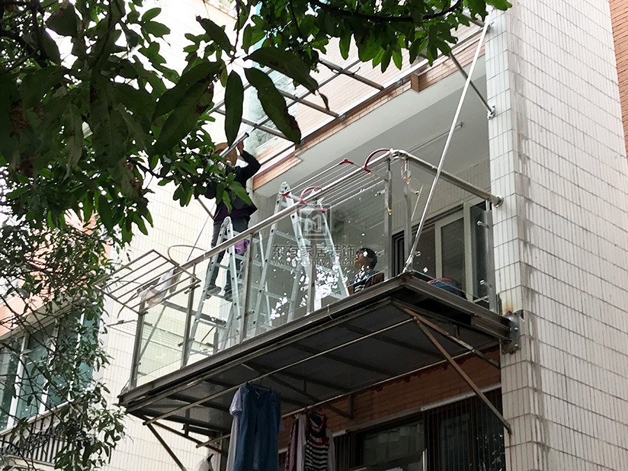 师傅正在给不锈钢雨棚的玻璃打胶
