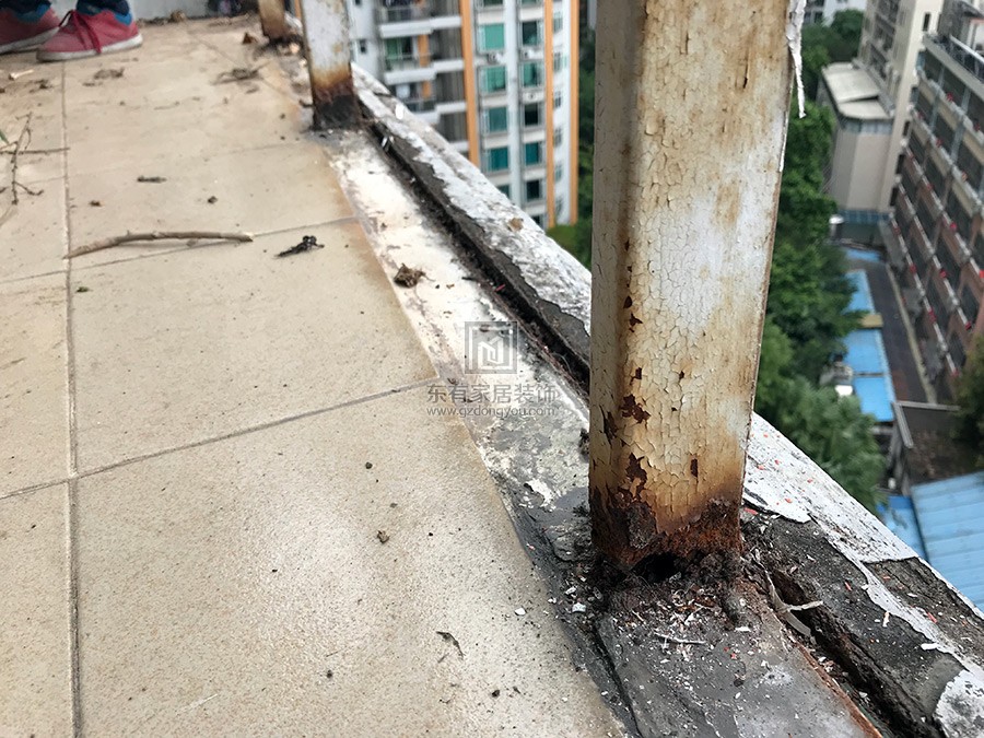 可见旧阳台铁栏杆立柱底部已生锈腐蚀，有断裂危险